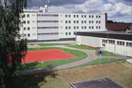 Blick auf Hafthaus 3 mit Hofgelände und Volleyballplatz.